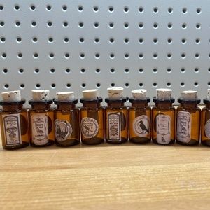 10 Small Brown Glass Bottles with Varying Apothecary Stickers Attached